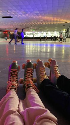 two people sitting on the floor with their feet up in front of them and one person wearing sneakers