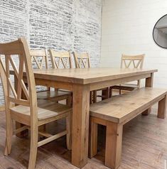 a wooden table and bench in front of a brick wall with white bricks on it