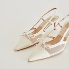 a pair of women's white shoes with bows