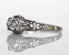 an antique style diamond ring with filigree accents