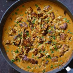 a pan filled with meat and vegetables on top of a table