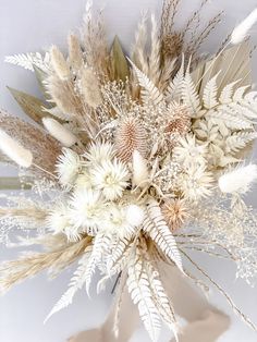 an arrangement of dried flowers on a white background