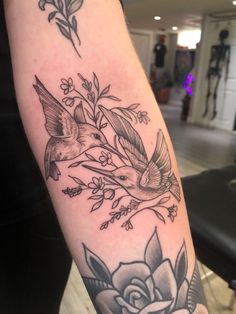 a bird and flower tattoo on the arm