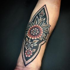 a black and white flower tattoo on the left arm, with an intricate design in the middle