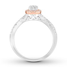 an engagement ring with two tone gold and white diamonds on the sides, set in 18k