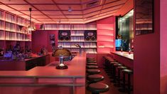 a bar with lots of stools in front of it and shelves full of books