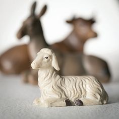 small figurines of sheep and donkeys are sitting on the floor next to each other