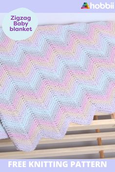 a crocheted baby blanket sitting on top of a wooden bench