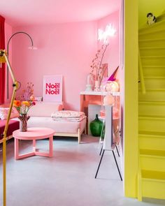 a living room with pink walls and yellow stairs