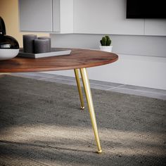 a wooden table with gold legs in a room next to a potted cacti