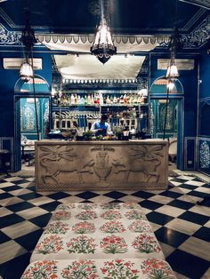 the interior of a restaurant with blue walls and checkered flooring, decorated with floral designs