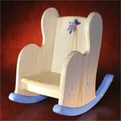 a wooden toy rocking chair with blue handles