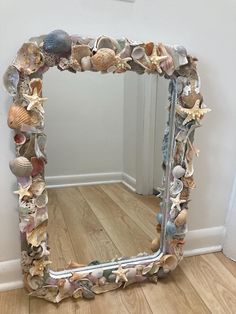 there is a mirror made out of seashells on the floor