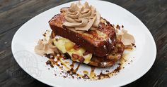 a white plate topped with french toast covered in toppings