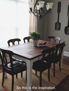 a dining room table with chairs and a bowl of fruit on it in front of a window