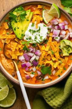 a bowl filled with chicken tortilla soup and garnished with sour cream