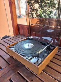 an old record player sitting on top of a wooden table