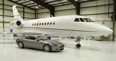 a car is parked in front of a private jet