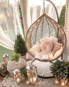 a hanging chair with pillows and books on it