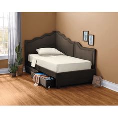 a bed with a headboard and foot board is shown in the corner of a room