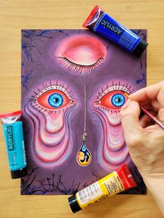 someone is painting an evil face on a piece of paper with acrylic paint