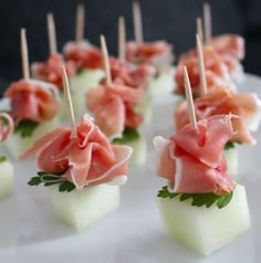 small appetizers with toothpicks are displayed on a plate