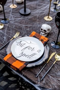 a table set for halloween with plates and silverware