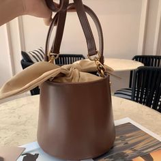 Expertly crafted from top-quality materials, this mini bag is unique and playful. A modern bucket bag, this piece comes in a rounded silhouette with bunny ear designs. You'll love the smooth look and feel of the luxurious leather, metal hardware, and youthful spirit of this leather accessory.Weight: 470 gHeight (cm): 17 Color: BrownStrap Length: 100-112 cmInterior Material: Flannel, PU leatherMaterial_bag: PU LeatherBagType: Handbag & Crossbody bagBag Length: 18 cm Bucket Bag With Detachable Strap And Top Handle, Gift Bucket Bag With Detachable Strap And Top Handle, Trendy Brown Bucket Bag, Brown Bucket Bag With Detachable Handle As Gift, Trendy Bucket Bag With Detachable Handle, Bucket Shoulder Bag With Detachable Handle As Gift, Detachable Handle Bucket Shoulder Bag For Gift, Detachable Handle Bucket Shoulder Bag Gift, Handheld Bucket Bag With Dust Bag