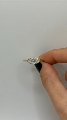 a person is holding a ring with a diamond on the top and bottom half of it