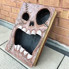 a book shaped like a skeleton with its mouth open and teeth wide open, sitting on the ground