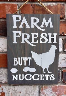 a sign that says farm fresh but nuggets hangs on a brick wall in front of a brick building