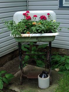 an old sink with flowers growing out of it