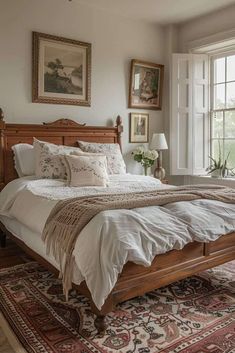 a bedroom with a bed, rugs and pictures hanging on the wall above it