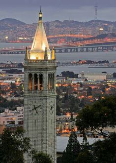 a clock tower in front of the city lights