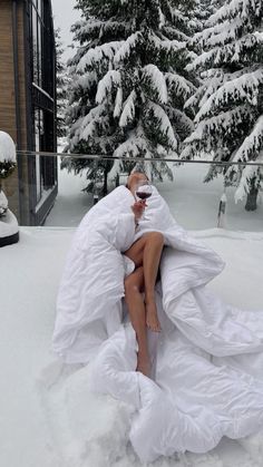 a woman sitting on top of a bed covered in snow