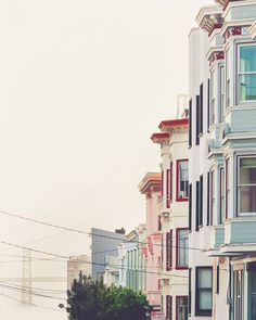 a row of multi - colored houses on a foggy day