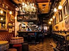 the interior of a bar with chandeliers hanging from the ceiling