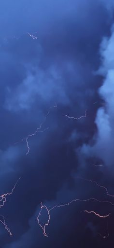 the sky is filled with lightning as it moves through the dark blue cloudy skies above