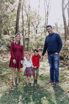 a man and two women holding hands while standing in the woods with three children on their laps