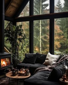 a living room filled with furniture and a fire place in front of a large window