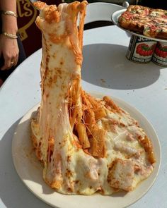 a white plate topped with pizza covered in cheese and sauce on top of a table