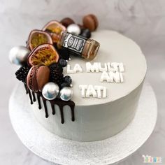 a white cake with chocolate and fruit on top that says la must tat,