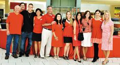 a group of people standing next to each other in front of a red counter top