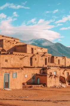 an adobe style building with mountains in the background