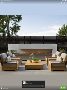 an outdoor living room with couches, tables and a fire place in the center