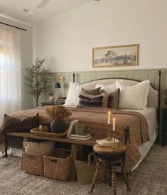 a bedroom with a bed, table and two baskets on the floor next to it