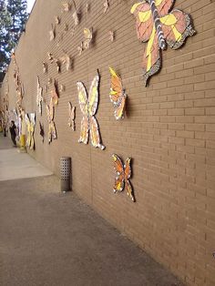 a brick wall with many butterflies on it