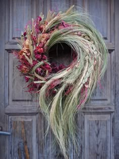 a dried wreath is hanging on the front door