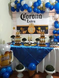 a table topped with balloons and desserts next to a sign that says corona extra