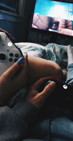 a person is holding a remote control in their hand while playing a video game on the tv